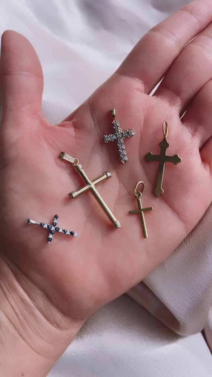 Video of Multiple Catholic Cross Pendants on Hand for Scale