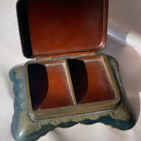 an antique Art Deco stamp box with decorative top and Greek key design