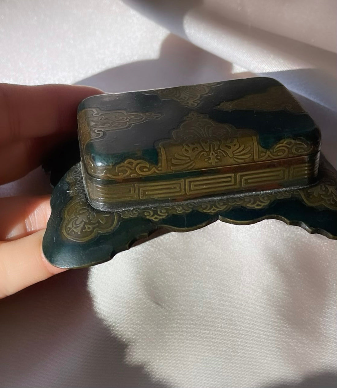 an antique Art Deco stamp box with decorative top and Greek key design