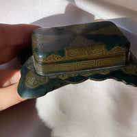 an antique Art Deco stamp box with decorative top and Greek key design