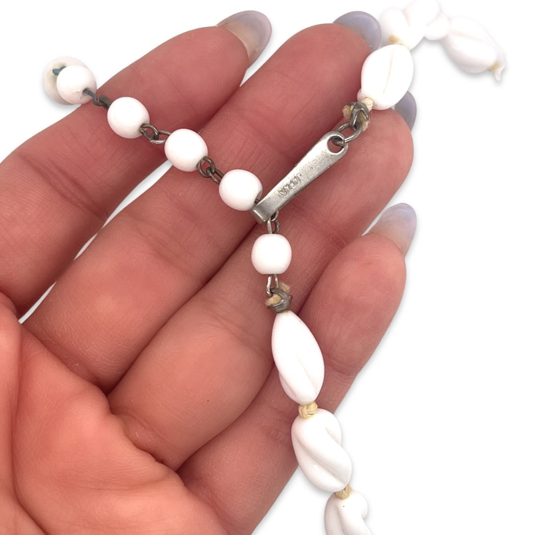 A close-up on the clasp of the vintage 1950s Mid Century white ceramic bead and crystal necklace