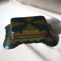an antique Art Deco stamp box with decorative top and Greek key design
