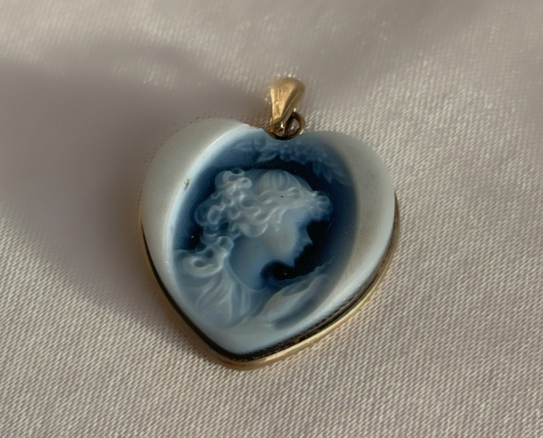 a white and blue Wedgwood jasperware porcelain cameo of a woman in the shape of a heart pendant set in yellow gold