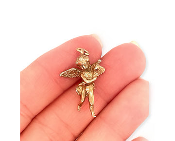 a vintage 10k rose gold 3d cherub pendant, shown in hand
