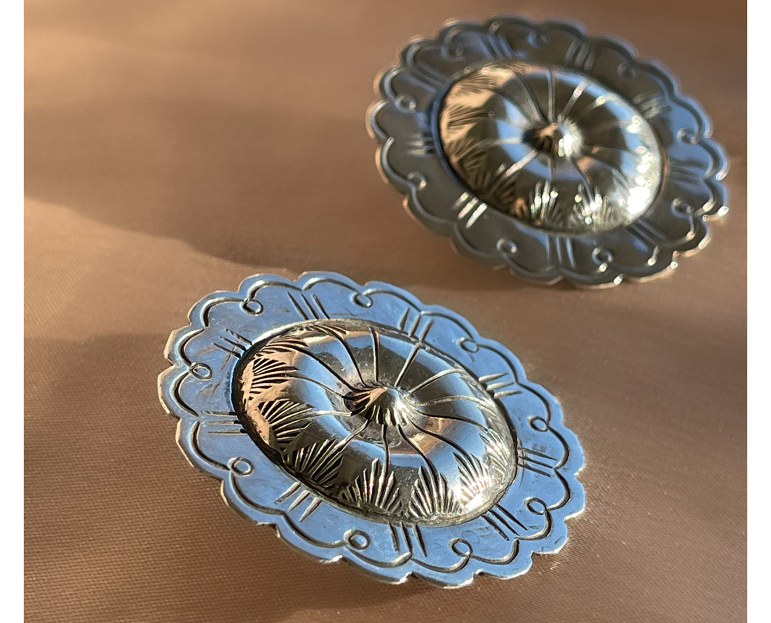 A pair of hand hammered stamped Native American Navajo concho shaped stud statement earrings in sterling silver