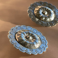 A pair of hand hammered stamped Native American Navajo concho shaped stud statement earrings in sterling silver