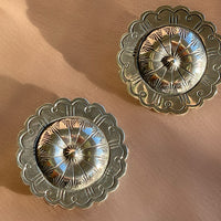 A pair of hand hammered stamped Native American Navajo concho shaped stud statement earrings in sterling silver