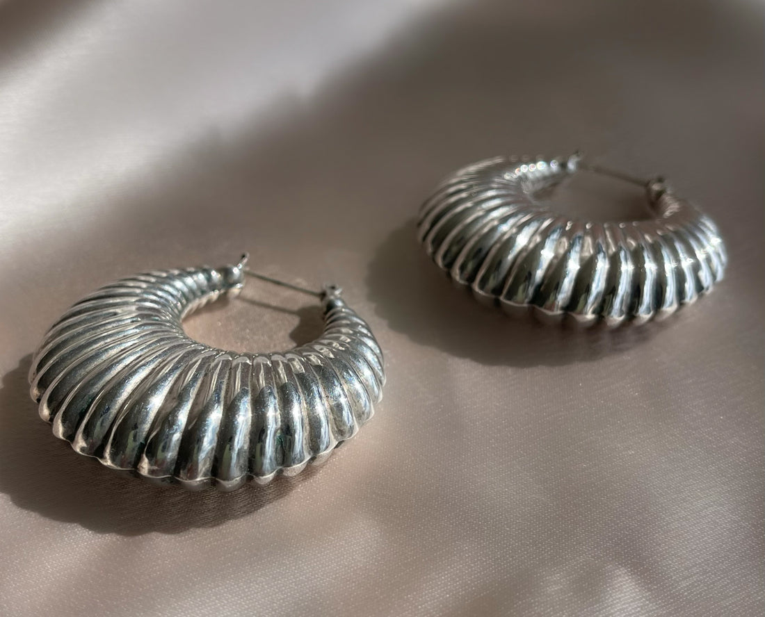 A pair of vintage sterling silver puffy croissant-style textured hoop statement earrings
