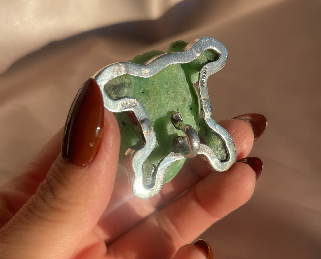 A vintage hand carved green jade frog with glass eyes set in sterling silver