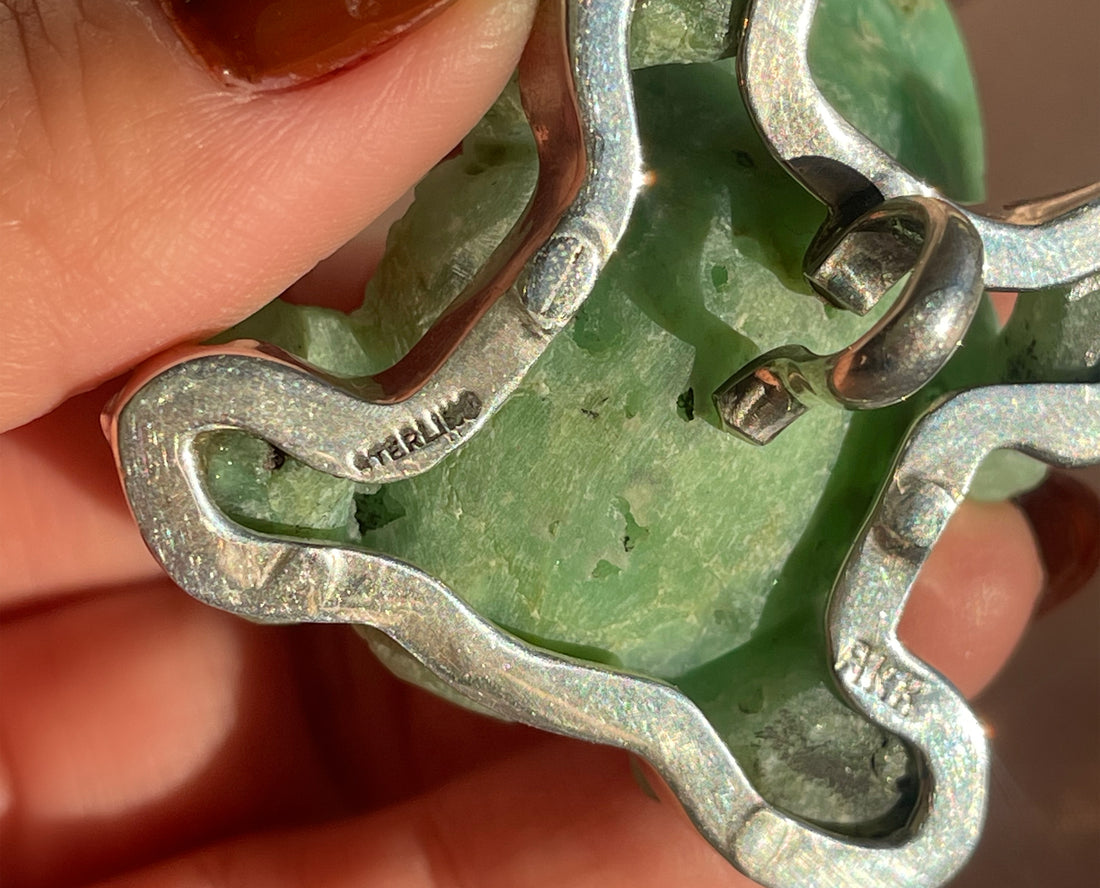 A vintage hand carved green jade frog with glass eyes set in sterling silver