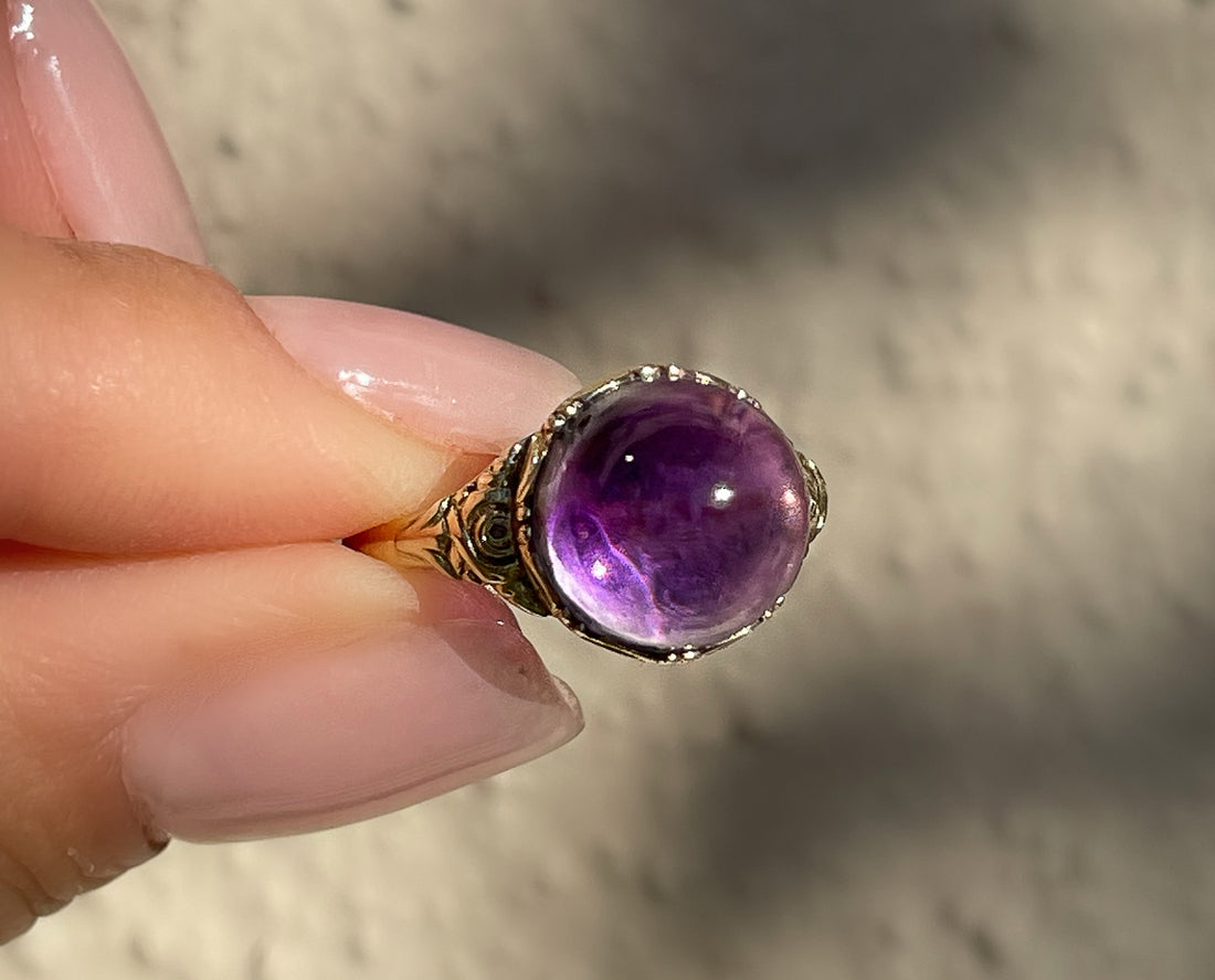 Antique Victorian sugarloaf cabochon amethyst ring with pie-crust bezel and repousse detail on shank in 14k yellow gold