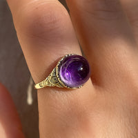 Antique Victorian sugarloaf cabochon amethyst ring with pie-crust bezel and repousse detail on shank in 14k yellow gold