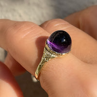 Antique Victorian sugarloaf cabochon amethyst ring with pie-crust bezel and repousse detail on shank in 14k yellow gold