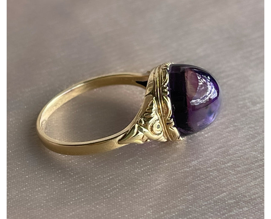 Antique Victorian sugarloaf cabochon amethyst ring with pie-crust bezel and repousse detail on shank in 14k yellow gold
