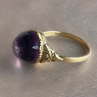 Antique Victorian sugarloaf cabochon amethyst ring with pie-crust bezel and repousse detail on shank in 14k yellow gold