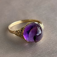 Antique Victorian sugarloaf cabochon amethyst ring with pie-crust bezel and repousse detail on shank in 14k yellow gold